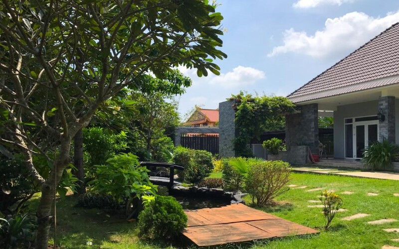 alt: Sân vườn biệt thự phong cách Châu Âu với đài phun nước và cây xanh được cắt tỉa tỉ mỉ